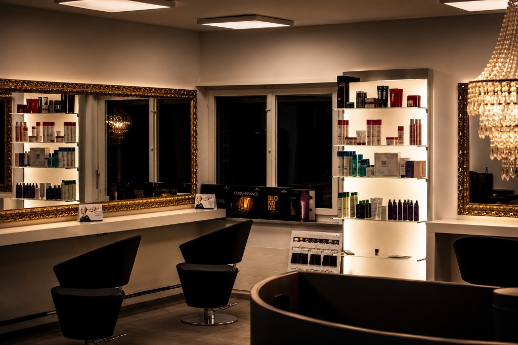Lange Styling-Theke, Goldspiegel und hinterleuchtetes Produktregal